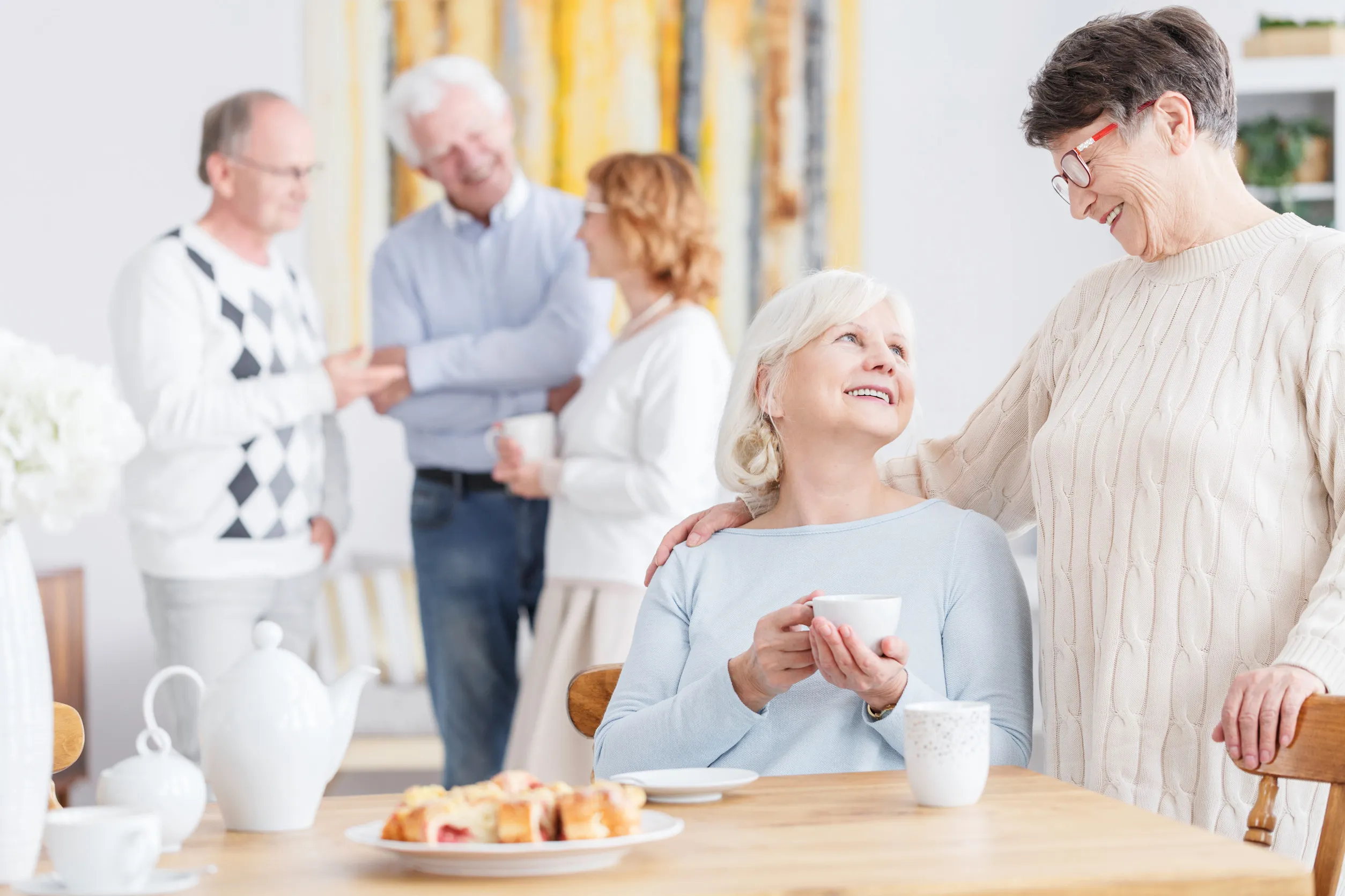 Elderly friends on a tea party at neighbor's home